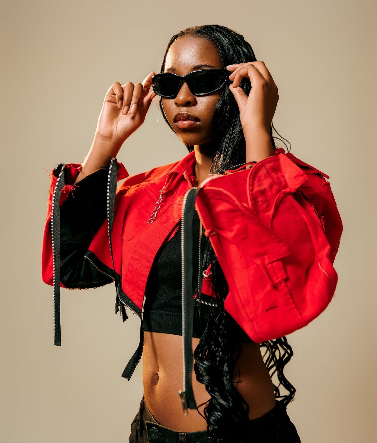 Pheme Katjene close up in the red Banks jacket, lowering her sunglasses